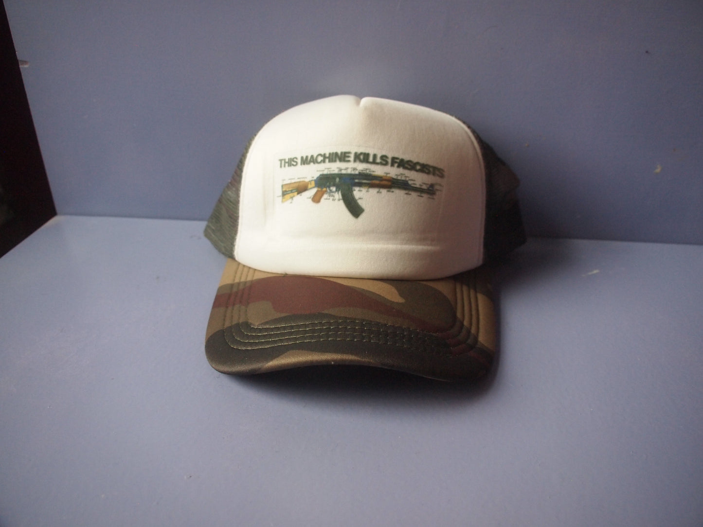 "This Machine Kills Fascists" AK-47 Camo Trucker Hat