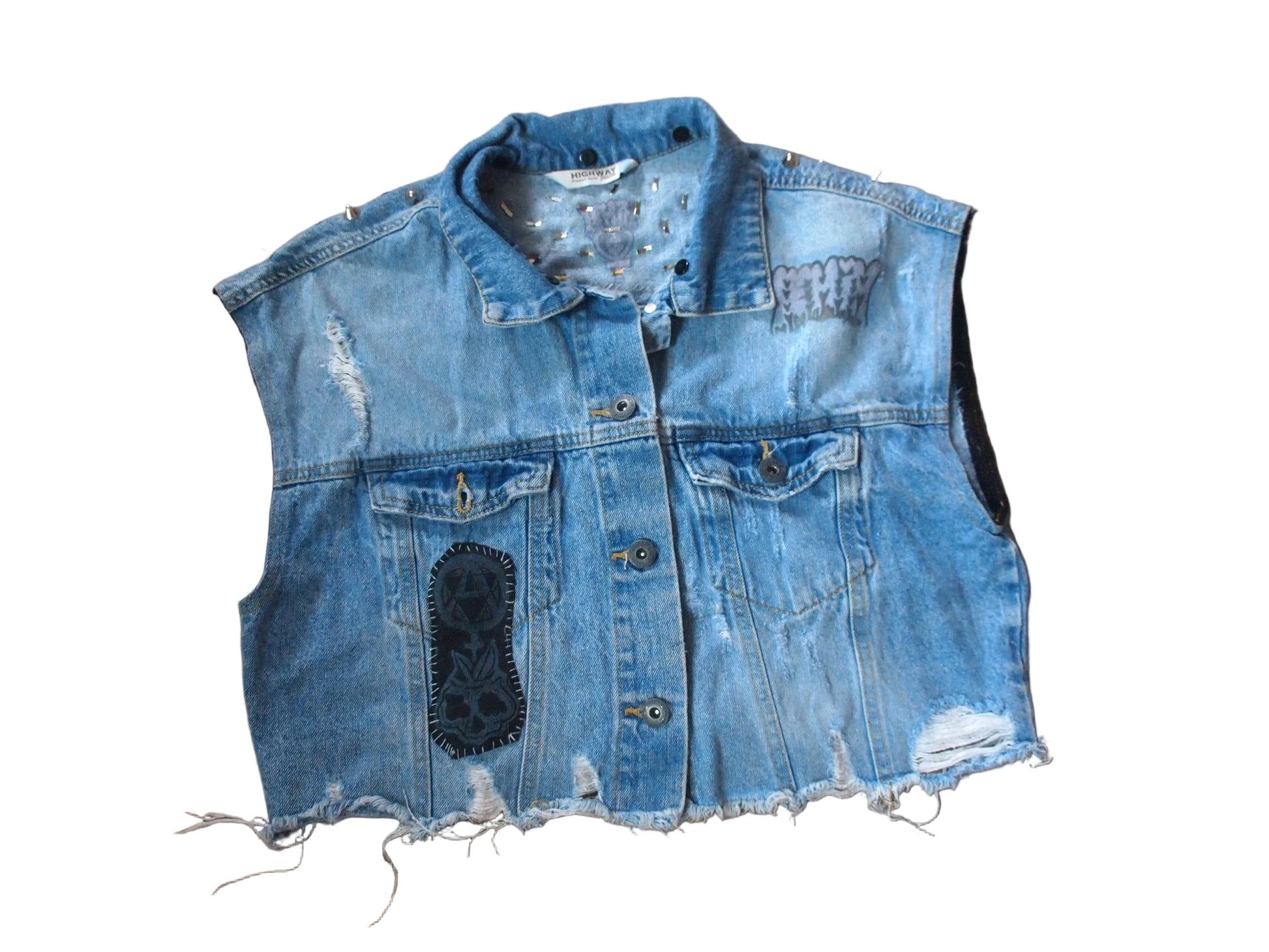 A light blue distressed denim vest with frayed edges, button front, and a black patch on the front.