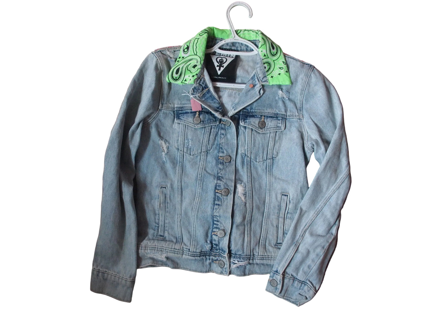 A light blue distressed denim jacket with a bright green paisley bandana collar.